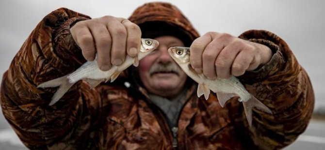 Buzla kaplı gölde balık tutarak savaşın stresini atmaya çalışıyorlar