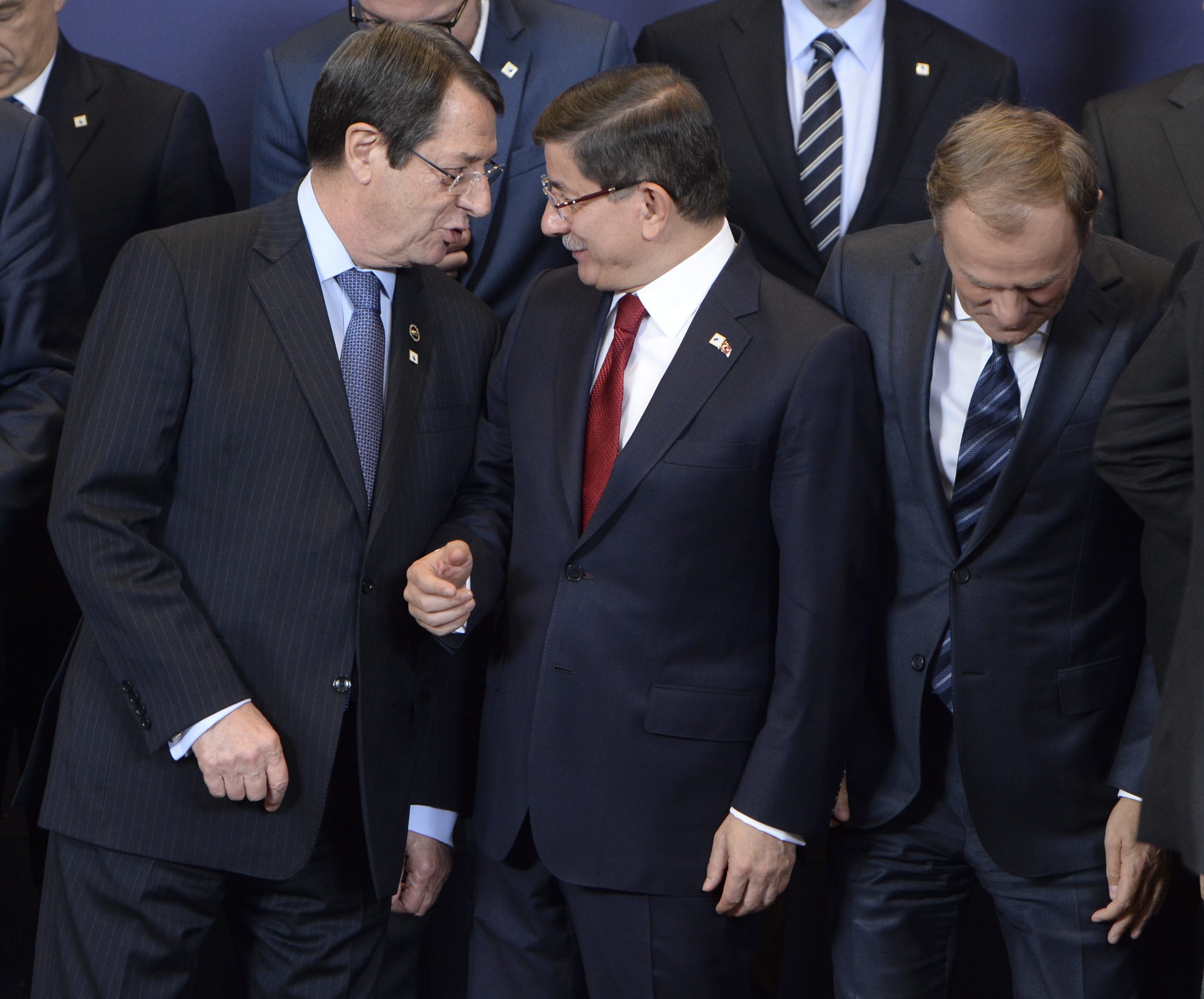 epa05047621 Cypriot President Nicos Anastasiades (L-R), Turkish Prime Minister Ahmet Davutoglu, and EU Council President Donald Tusk line up for the family picture at the start of an EU-Turkey Summit in Brussels, Belgium, 29 November 2015. The European Union hopes to secure Ankara's concrete help in stemming a surge in migration, at a joint summit in Brussels, with the bloc offering financial aid and closer ties in return. Europe is facing its largest people movements since World War II, with almost 900,000 migrants and asylum seekers arriving this year. Many, including large numbers from war-torn Syria, transit through Turkey and board boats headed for Greece. EPA/STEPHANIE LECOCQ