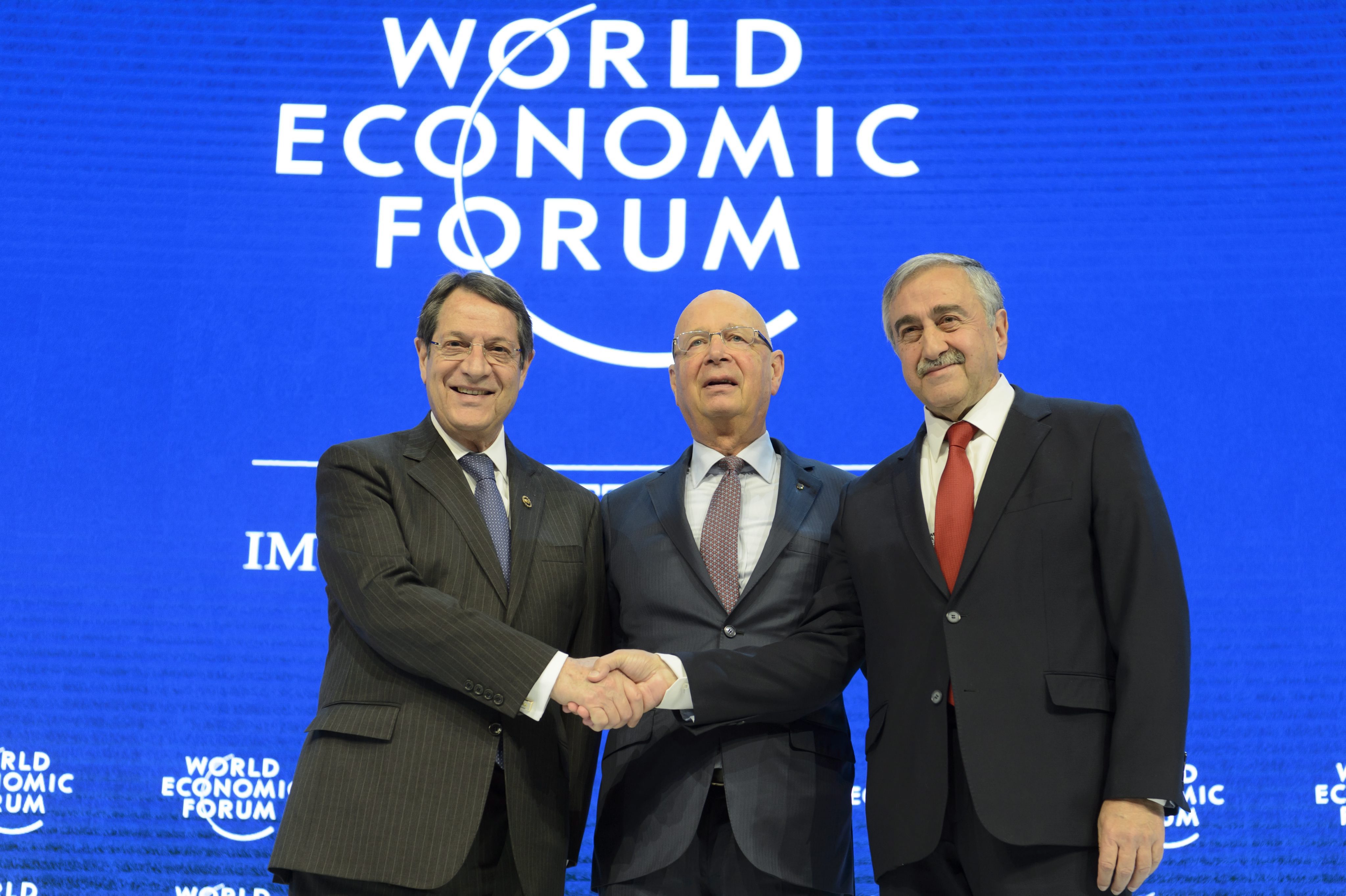 epa05115671 Nicos Anastasiades, (L), President of Cyprus shakes hands with Turkish Cypriot Leader Mustafa Akinci, (R), in front of German Klaus Schwab, (C), founder and president of the World Economic Forum, WEF, during a panel session during the 46th Annual Meeting of the World Economic Forum, WEF, in Davos, Switzerland, 21 January 2016. The overarching theme of the Meeting, which takes place from 20 to 23 January, is 'Mastering the Fourth Industrial Revolution.' EPA/LAURENT GILLIERON