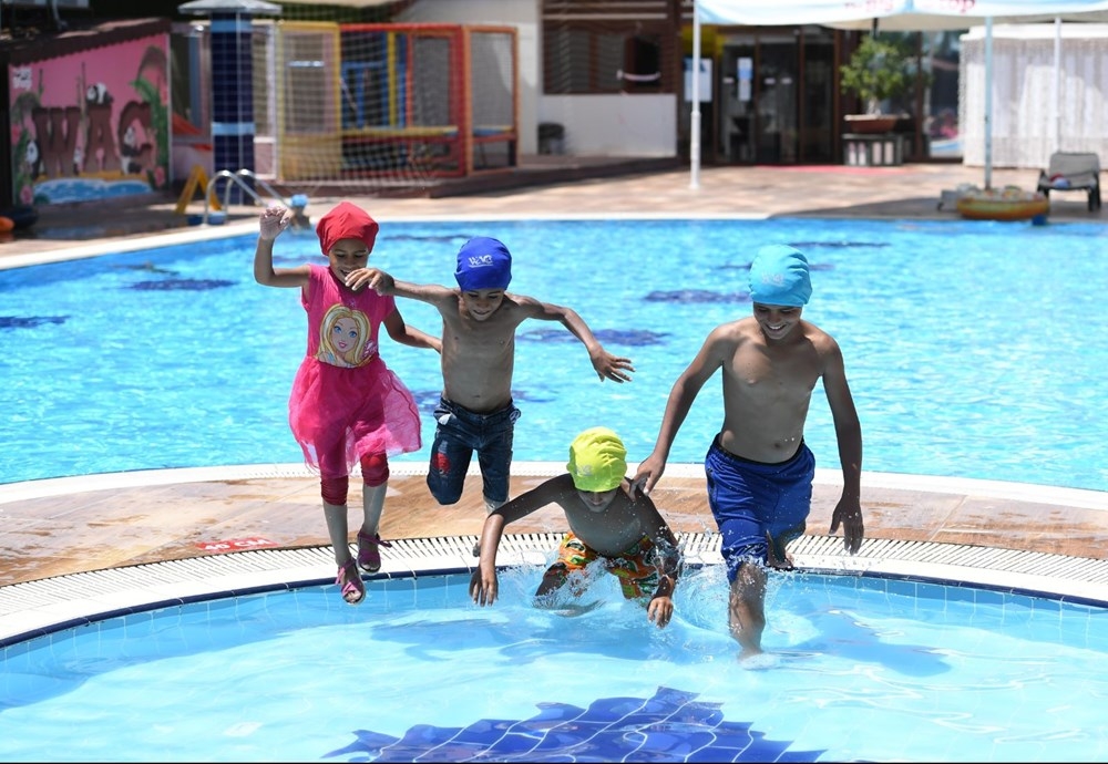 Çöp konteyneri üzerinden havuzdaki yaşıtlarını izleyen kağıt toplayıcı ç galerisi resim 2