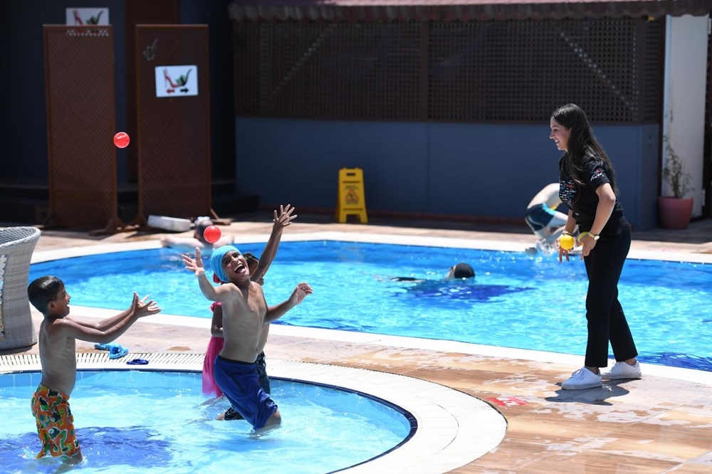 Çöp konteyneri üzerinden havuzdaki yaşıtlarını izleyen kağıt toplayıcı ç galerisi resim 3